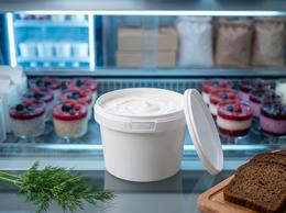 560 ml plastic bucket of sour cream in a refrigerated display case