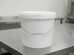 5.6 liter plastic bucket with lid on a workbench in a production shop