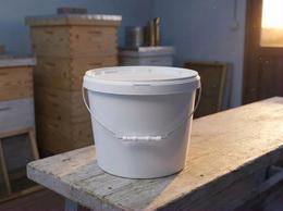 11.5 liter plastic bucket of honey in an apiary storeroom