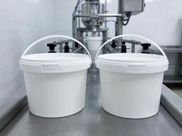 800 ml plastic bucket with a molded-in handle, filled with ayran on a filling line